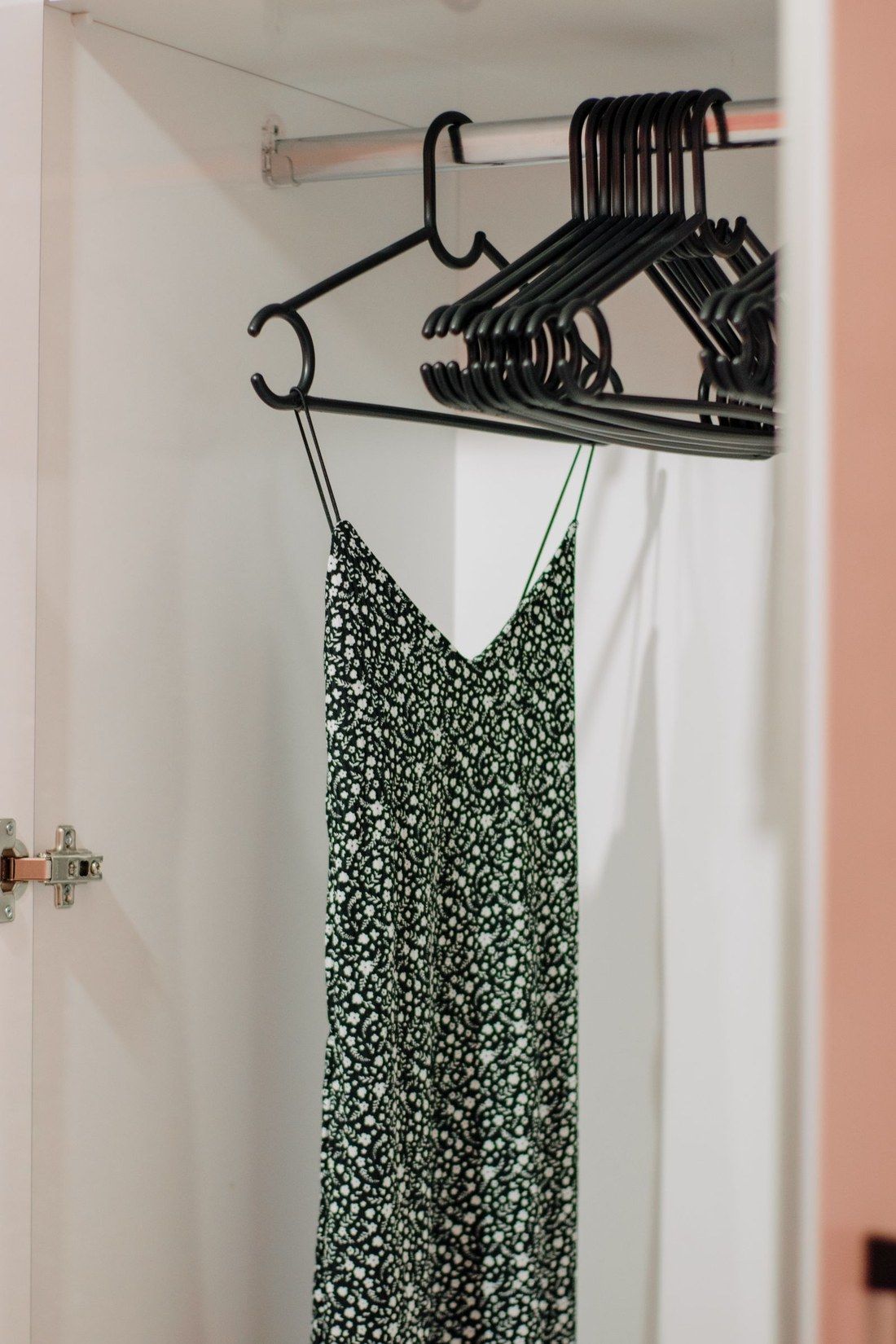 Schwarz-weiß gemustertes Trägerkleid auf einem Bügel im Schrank